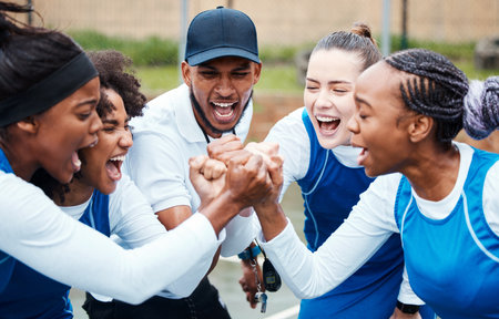 Fist, motivation or team support in netball training game screaming with hope or faith on sports court. Teamwork, fitness coach or group of excited athlete girls with pride or solidarity togetherの写真素材