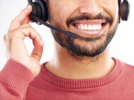 Call center consulting, mouth or happy man telemarketing on contact us CRM or telecom studio. Customer service communication, face headset mic and male consultant smile isolated on white backgroundの写真素材