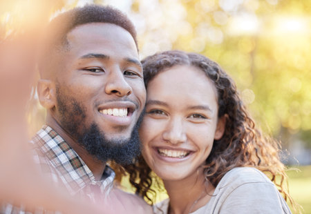 Couple of friends in portrait selfie at park for outdoor relax, happy date and interracial love on social media. Happy woman, gen z or young people in nature, profile picture post and smile togetherの写真素材