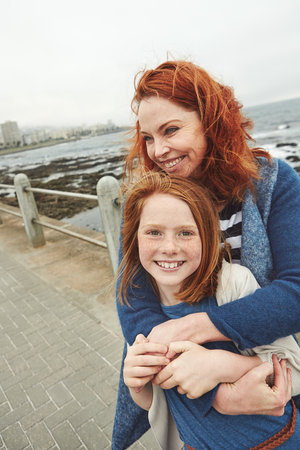 Our time together is priceless. a mature woman and her young daughter at the waterfront.の写真素材