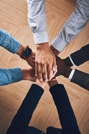 Teamwork, partnership or hands of business people in support for faith, vision or strategy in office. Above, diversity or employees in group collaboration with hope or mission for goals togetherの写真素材