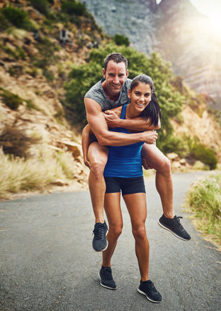 Im her weights. a young attractive couple training for a marathon outdoors.の写真素材
