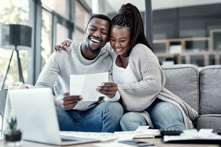 Be debt free, be happy. an affectionate young couple going through paperwork at home.の写真素材