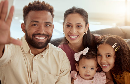 Parents, girl children and selfie on sofa with happiness, hand and photography for blog, post or portrait in family home. Father, mother and daughters with smile, social media app and profile pictureの写真素材