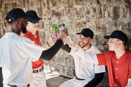 Baseball player, team or people toast to success in training or match game to celebrate victory in stadium. Goals target, fun men or softball players in happy celebration with sports drinks togetherの写真素材