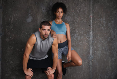 Fitness, wall background and couple in parking lot for workout, body builder training and exercise outdoors. Sports, mockup and man and woman sweating from running for endurance, wellness and energyの写真素材