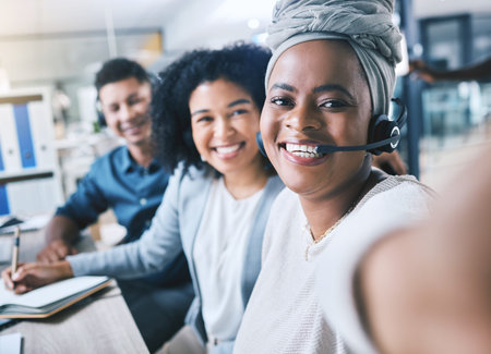 Diversity, portrait of colleagues with headset and taking a selfie together at their workplace desk...