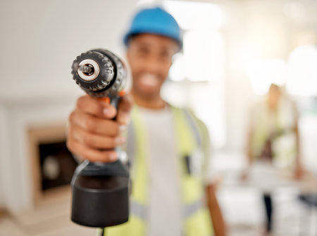 Engineer, handyman and drill in hand of a man for maintenance or carpenter work. Male construction worker, constructor or contractor with electric power tools at building site for renovation mockupの写真素材