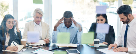 Meeting, planning and stress with a business team in a boardroom for strategy during a financial crisis. Finance, compliance or regulations with a group of colleagues in an office for problem solvingの写真素材