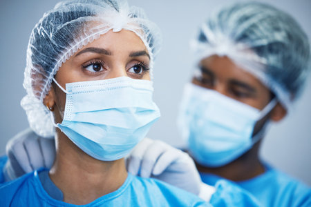 Uniform, preparation and doctor team getting ready in hospital for medical, innovation and operation. Healthcare, experts and woman with man in theater for surgery, teamwork and medical collaborationの写真素材