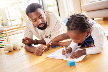 African father, girl and floor for drawing, paper and learning together with help, love and care in home lounge. Black man, daughter and teaching with toys, notebook and helping hand in family houseの写真素材