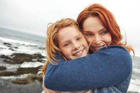 My favourite place is inside your hug. a mature woman and her young daughter at the waterfront.の写真素材