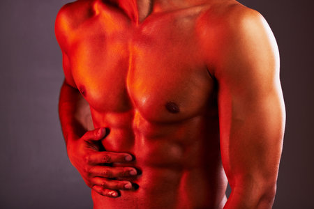 Fitness, neon and abdomen of man in studio for healthy body, muscles and self care on purple background. Creative aesthetic, glow and stomach of strong male model for exercise, wellness and skincareの写真素材