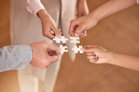 Business people, hands and puzzle piece in planning, teamwork or brainstorming for collaboration at office. Hand of group in team building, strategy or activity for engagement, support or interactionの写真素材