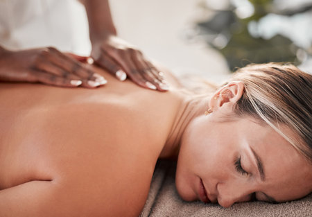 Hands, back massage with masseuse, woman at holistic center or spa with wellness, physical therapy and zen. Health, body rub at luxury resort and face with stress relief, self care and lifestyleの写真素材