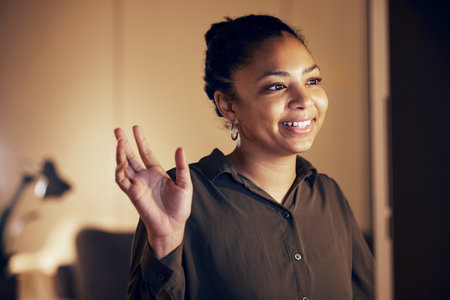 Video call communication, computer and night woman wave hello on online conference with business investment contact. Networking, conversation and person talking, happy and discussion on webinarの写真素材