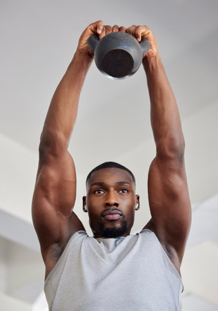 Kettlebell, exercise and black man doing training, wellness and workout for fitness, health and strength in sportswear. Male athlete, strong trainer and healthy for cardio, focus and weight lifting.の写真素材