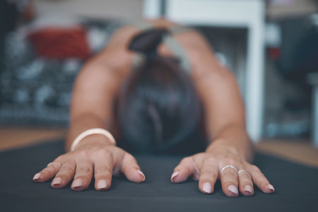 Even the gentlest forms of yoga are transformative. a young woman practising yoga at home.の写真素材