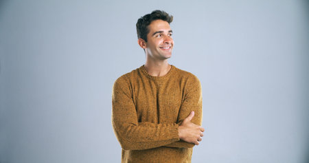 If you think you can, you can. Studio shot of a handsome young man looking thoughtful against a gray background.の写真素材