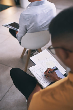 He came prepared. an unrecognizable businessperson writing in a notebook during a conference at...