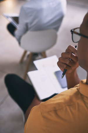 Taking down any important notes. an unrecognizable businessperson writing in a notebook during a conference at work.の写真素材