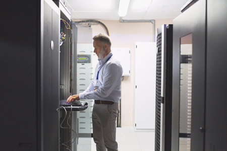 All will be sorted once I find the solution. a mature man using a laptop while working in a server...