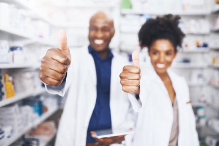 You can trust us. two pharmacists showing thumbs up.の写真素材