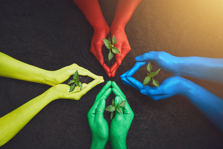 All of us should take part in making this world a better place. unrecognizable people holding budding plants in their multi colored hands.の写真素材