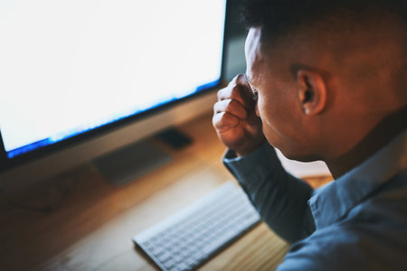 Its a sure way to end productivity. a handsome young businessman looking stressed while working late at night in a modern office.の写真素材