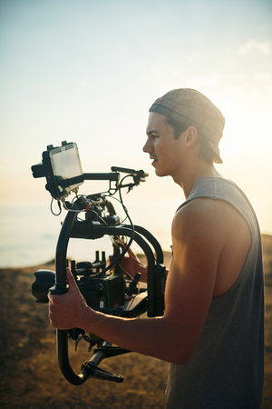 Getting the last shots in. a focused young man shooting a scene with a state of the art video camera...
