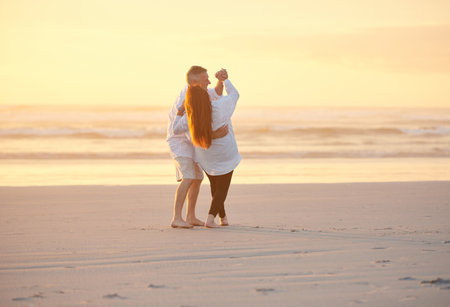 Retirement was was made for fun and romance. a mature couple dancing on the beach.の写真素材