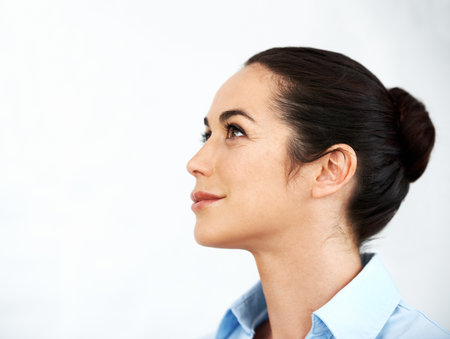 Envisioning her future. Beautiful businesswoman looking away while thinking against a white background.の写真素材