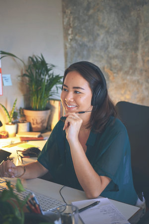 Hello How can I assist you today. an attractive young woman sitting alone and wearing a headset...