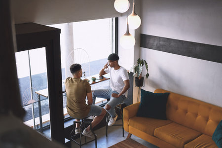 I just needed someone to talk to. two young men talking while having coffee together in a cafe.