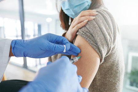 Give me your best shot. an unrecognizable doctor giving a patient an injection in an office.の写真素材
