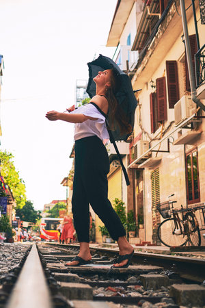 I feel more alive when I travel. a young woman holding an umbrella while exploring a foreign city on a sunny day.の写真素材