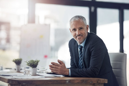 I always get the job done. Portrait of a mature businessman sitting at his desk in the office.