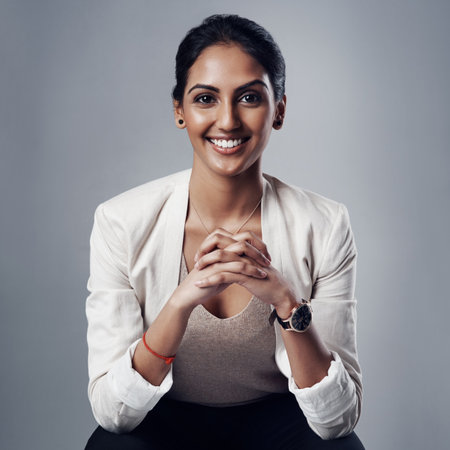 Taking on business with composure, confidence and credibility. Studio portrait of a young businesswoman posing against a gray background.の写真素材