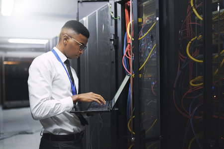 Never let your security slide. a young male technician working in a server room.