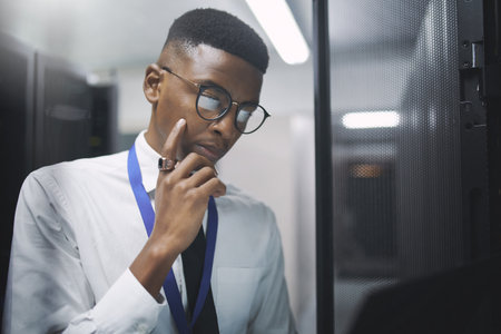 Its time for an upgrade. a young male IT technician in a server room.の写真素材