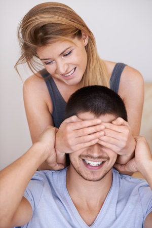 Guess who it is. Playful young couple spending time together at home.の写真素材
