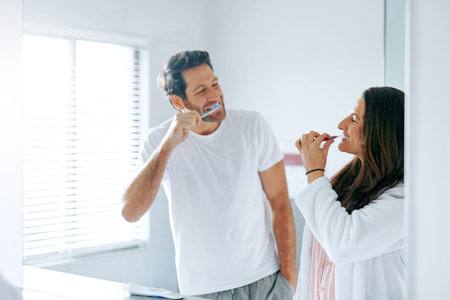 The first one who laughs is the loser. a couple brushing their teeth in the bathroom at home...