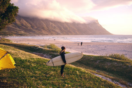 This weekend is all about surfing. an attractive young woman camping at her favourite surfing spot.の写真素材