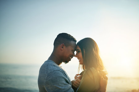 I fell in love the day we met. a young couple on the beach at sunset.の写真素材