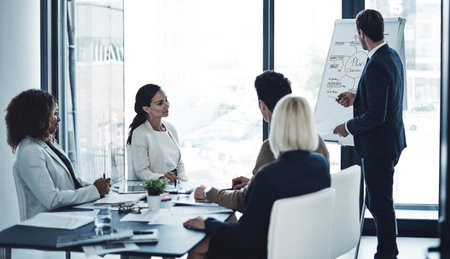 Letting his success speak for him. a corporate businessman giving a presentation to his colleagues in the boardroom.の写真素材