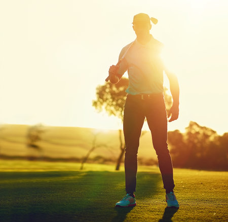 Hitting the course hard today. a young man playing golf.の写真素材