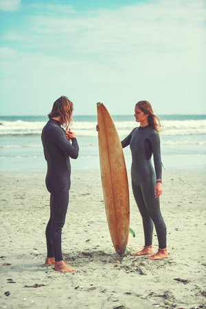 The perfect day with the perfect person. a young couple surfing at the beach.