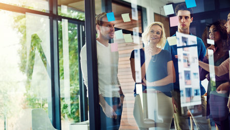 Seeing a plan come together is the best. a group of young designers brainstorming with notes on a...