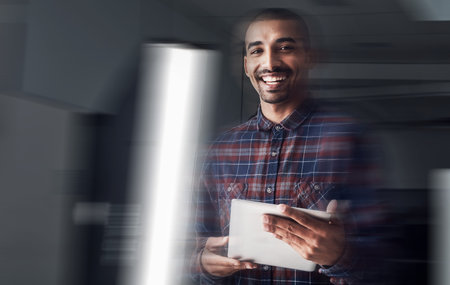 I always work with technology in hand. Portrait of a young entrepreneur working on a digital tablet...
