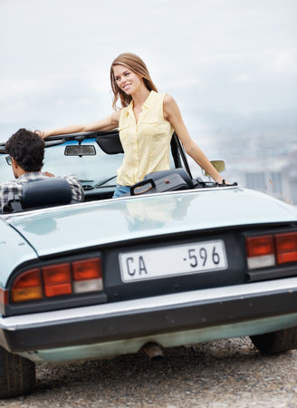Enjoying this great view. An attractive young couple in their convertible while on a roadtrip.の写真素材